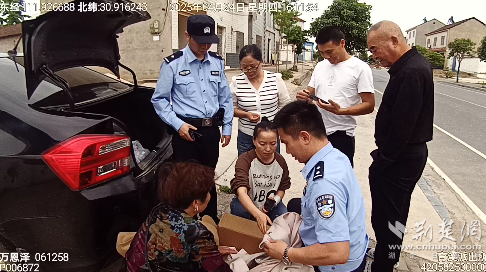 图说:民警和王女士夫妇查看拦截下旧衣服包裹的现金快递.png.png