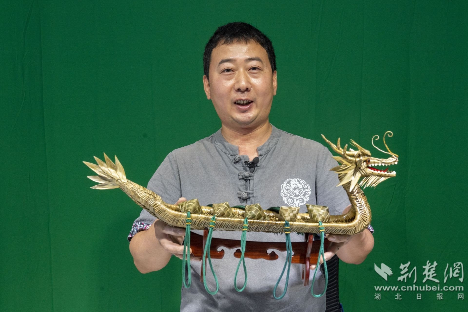 6月30日,秭归县峡江草编传承人罗光林展示草编龙舟。 周仕伟 摄.JPG.JPG